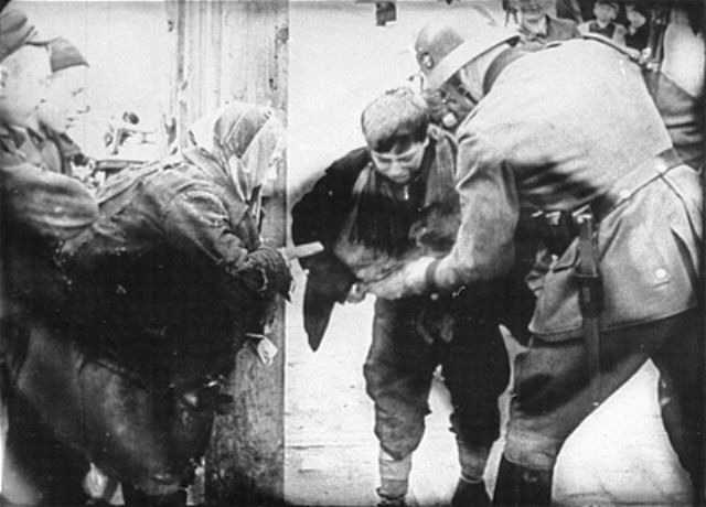 A young boy caught smuggling in the Warsaw ghetto by a German policeman
